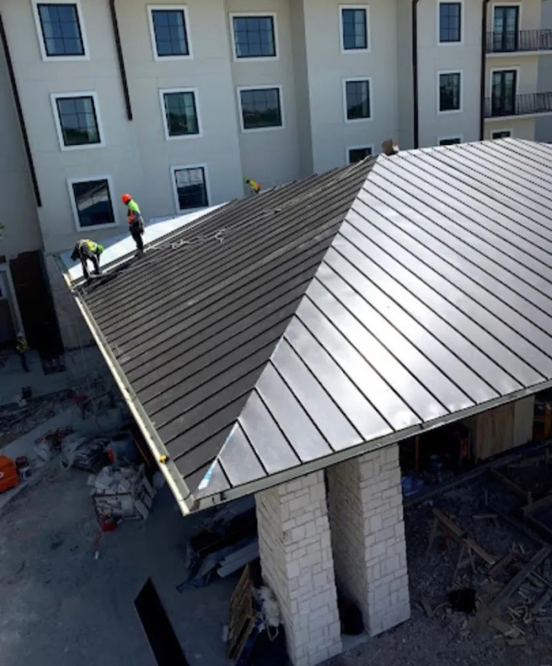 Crew installing standing seam metal roof panels on a commercial project in Orting